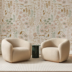 Papier peint panoramique Marguerites et Épis Beige Rosé, posé sur toute la paroi d'un salon, derrière deux fauteuils en bouclette crème et un guéridon en marbre vert