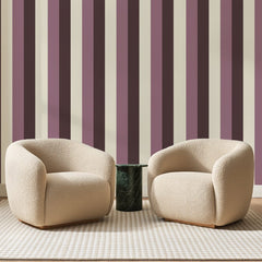 Papier peint panoramique Rayures Larges Rose et Prune, posé sur toute la paroi d'un salon, derrière deux fauteuils en bouclette crème et un guéridon en marbre vert