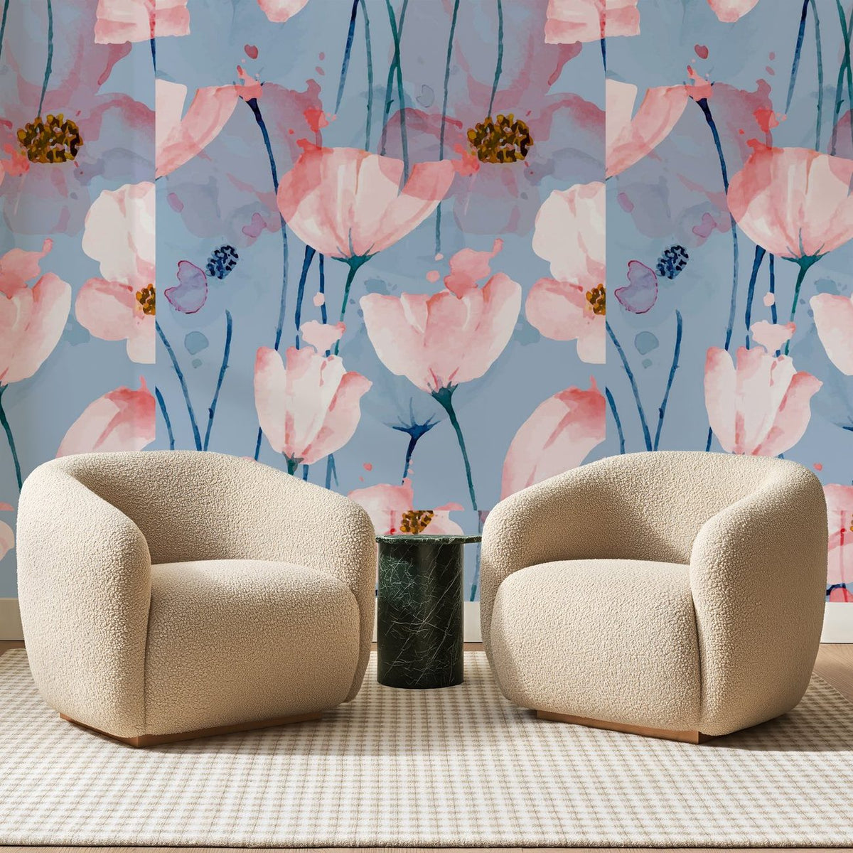 Papier peint panoramique Coquelicots Rosés sur Bleu Lin, posé sur toute la paroi d'un salon, derrière deux fauteuils en bouclette crème et un guéridon en marbre vert