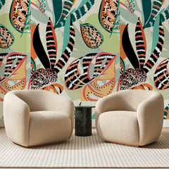 Papier peint panoramique Forêt Tropicale Corail et Vert, posé sur toute la paroi d'un salon, derrière deux fauteuils en bouclette crème et un guéridon en marbre vert