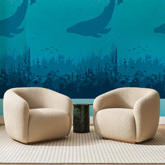 Papier peint panoramique Fonds Marins Bleu Turquoise, posé sur toute la paroi d'un salon, derrière deux fauteuils en bouclette crème et un guéridon en marbre vert