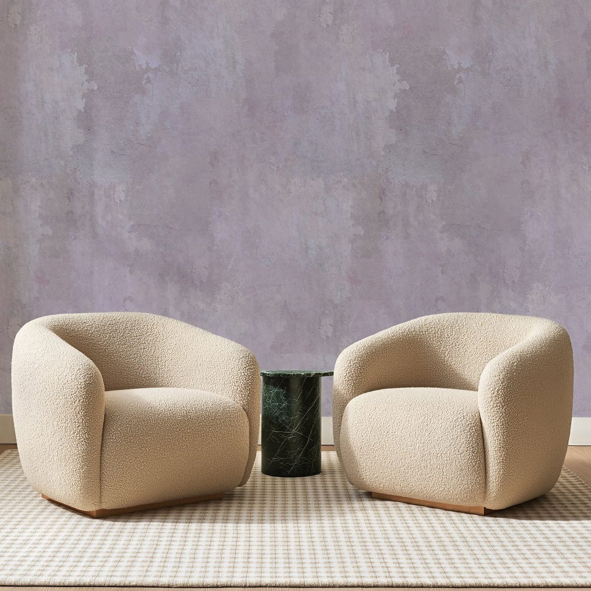Papier peint panoramique Enduit Rose Poudré, posé sur toute la paroi d'un salon, derrière deux fauteuils en bouclette crème et un guéridon en marbre vert