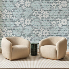 Papier peint panoramique Dentelle Fleurie Bleu Pâle, posé sur toute la paroi d'un salon, derrière deux fauteuils en bouclette crème et un guéridon en marbre vert