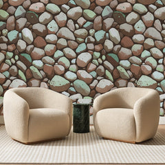 Papier peint panoramique Galets Texturés Terre Cuite, posé sur toute la paroi d'un salon, derrière deux fauteuils en bouclette crème et un guéridon en marbre vert