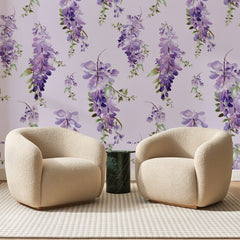 Papier peint panoramique Glycine Mauve Fond Lilas, posé sur toute la paroi d'un salon, derrière deux fauteuils en bouclette crème et un guéridon en marbre vert