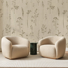 Papier peint panoramique Graminées sur Toile Beige, posé sur toute la paroi d'un salon, derrière deux fauteuils en bouclette crème et un guéridon en marbre vert