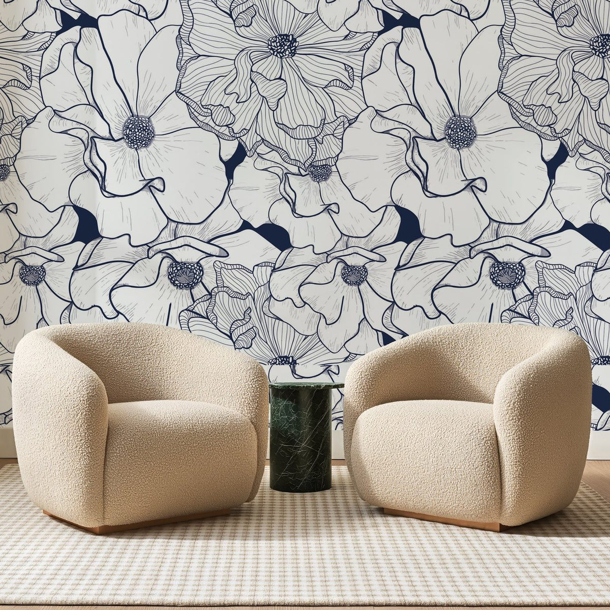 Papier peint panoramique Fleurs au Trait Bleu Marine, posé sur toute la paroi d'un salon, derrière deux fauteuils en bouclette crème et un guéridon en marbre vert
