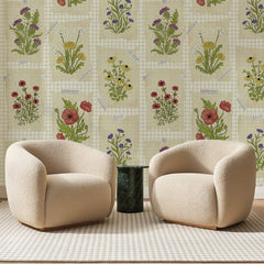 Papier peint panoramique Bouquets Champêtres Crème, posé sur toute la paroi d'un salon, derrière deux fauteuils en bouclette crème et un guéridon en marbre vert