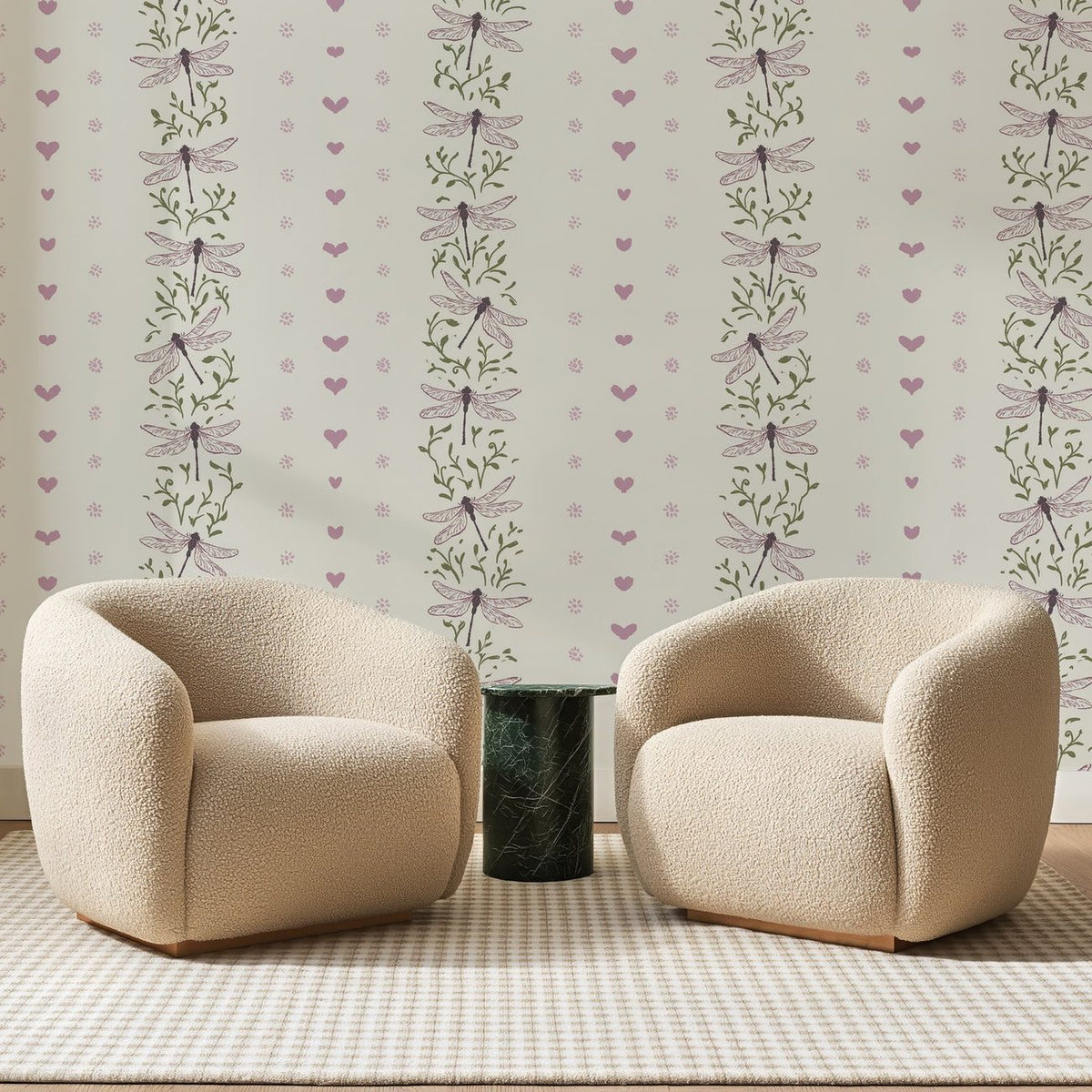 Papier peint panoramique Cœurs Et Libellules Mauves, posé sur toute la paroi d'un salon, derrière deux fauteuils en bouclette crème et un guéridon en marbre vert