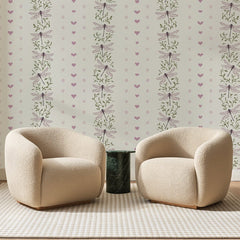 Papier peint panoramique Cœurs Et Libellules Mauves, posé sur toute la paroi d'un salon, derrière deux fauteuils en bouclette crème et un guéridon en marbre vert