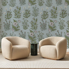 Papier peint panoramique Fleurs des Champs sur Bleu, posé sur toute la paroi d'un salon, derrière deux fauteuils en bouclette crème et un guéridon en marbre vert