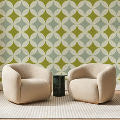 Papier peint panoramique Étoiles Rétro Vert Olive, posé sur toute la paroi d'un salon, derrière deux fauteuils en bouclette crème et un guéridon en marbre vert