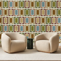 Papier peint panoramique Cadres Rétro Ocre Et Olive, posé sur toute la paroi d'un salon, derrière deux fauteuils en bouclette crème et un guéridon en marbre vert