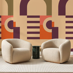 Papier peint panoramique Arches Rétro Prune Et Abricot, posé sur toute la paroi d'un salon, derrière deux fauteuils en bouclette crème et un guéridon en marbre vert