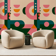 Papier peint panoramique Formes Rétro Sapin et Corail, posé sur toute la paroi d'un salon, derrière deux fauteuils en bouclette crème et un guéridon en marbre vert